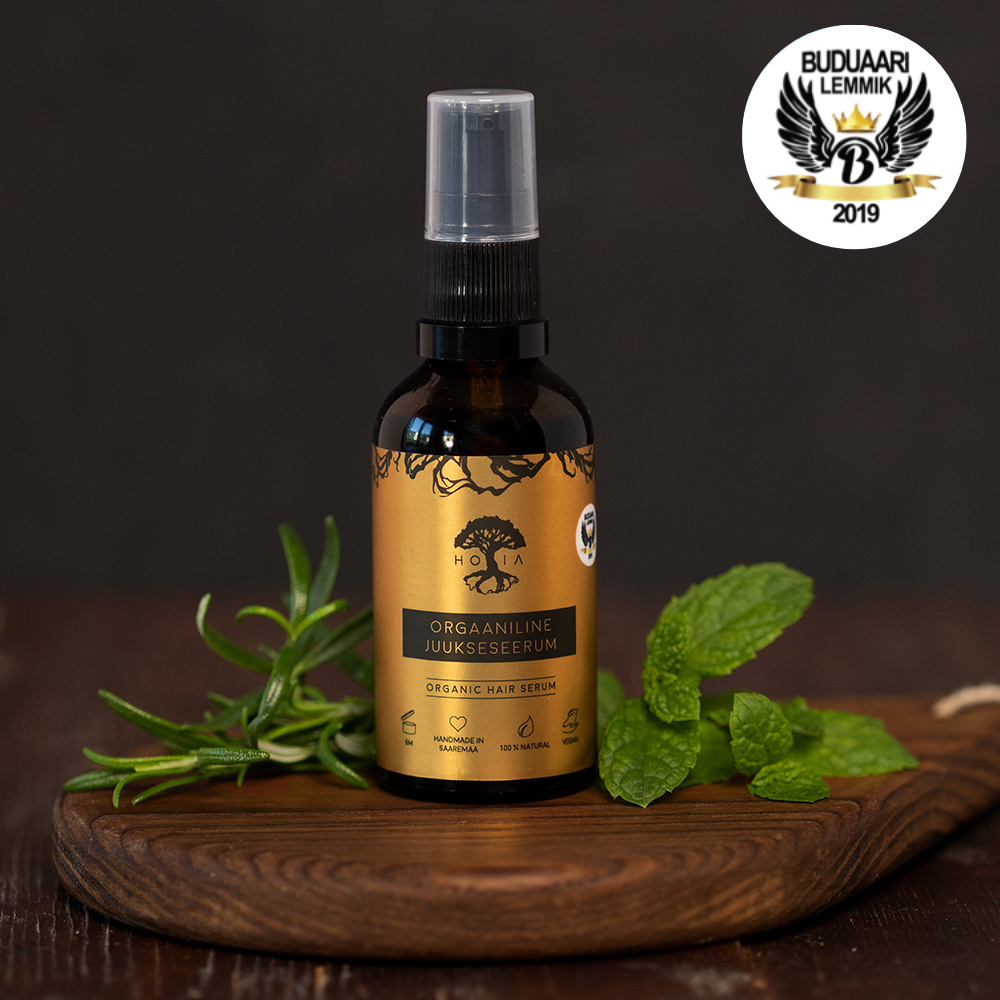 HOIA's award-winning natural cosmetics Hair Serum on a wooden tray